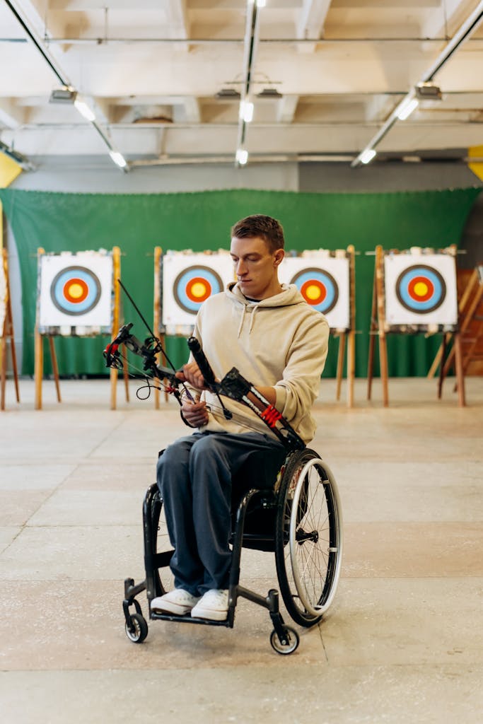 A wheelchair user taking part in indoor archery.