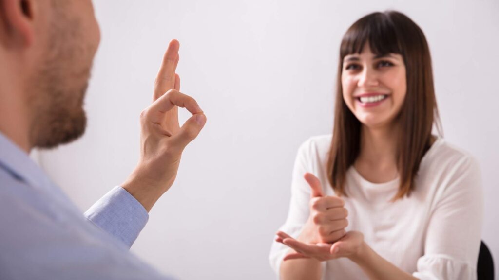 Two people communicating using sign language during a conversation.