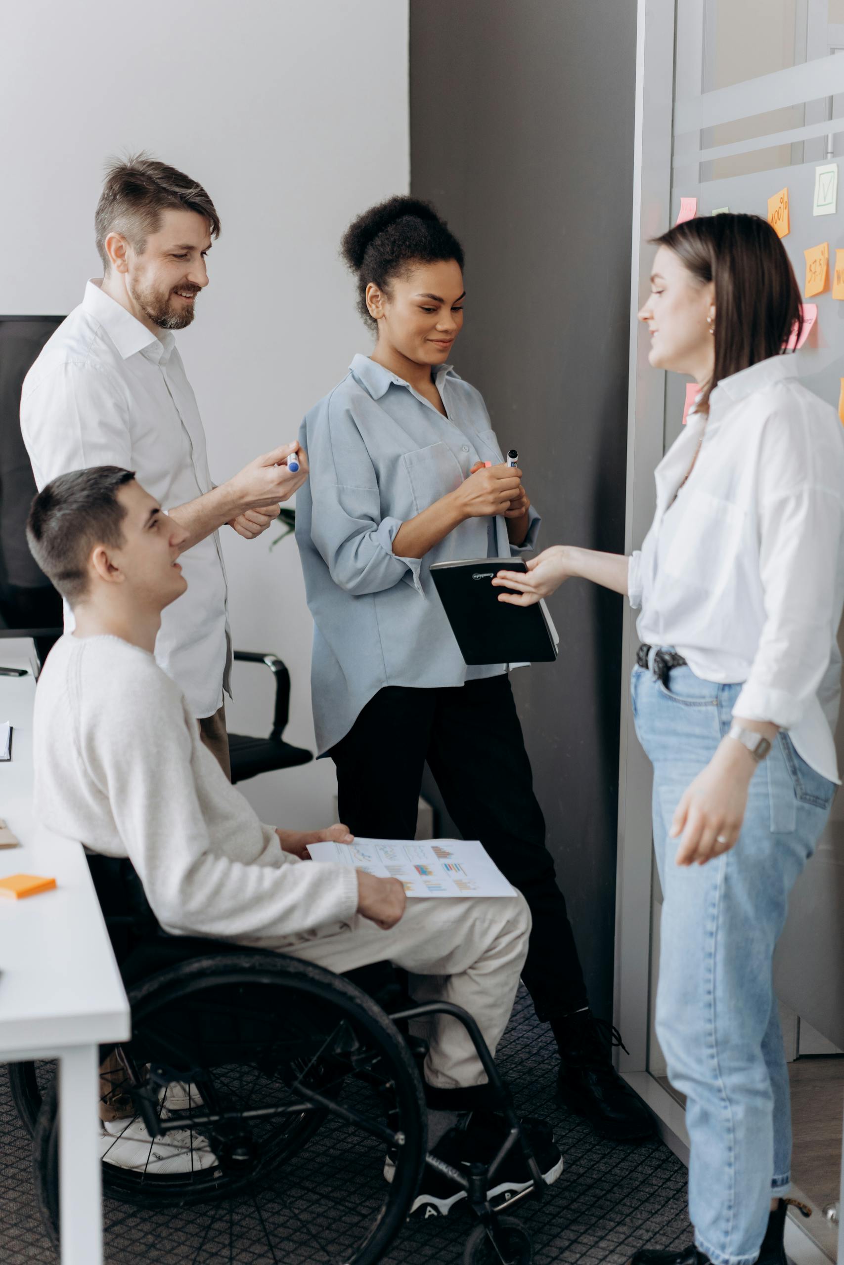 A diverse group of professionals collaborating in an office setting, fostering teamwork and inclusion.